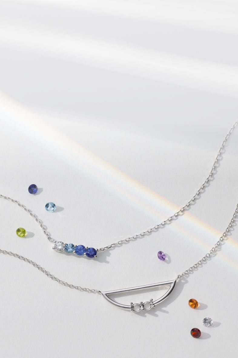 A collection of gemstone necklaces surrounded by loose colored gemstones