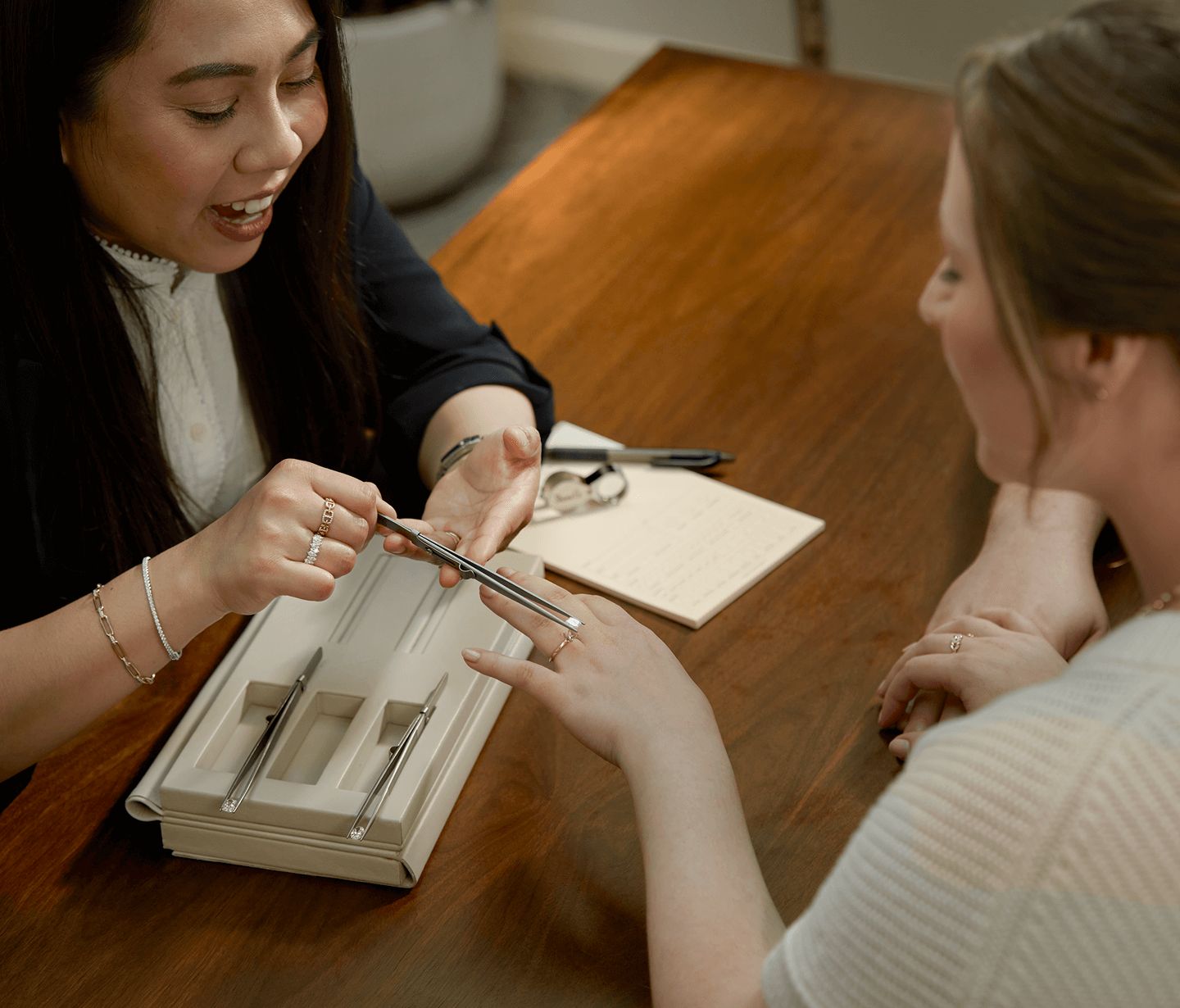 A jewelry consultant helping a customer decide on a diamond for their engagement ring