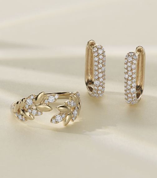 A pair of diamond fashion earrings and a diamond fashion laurel ring