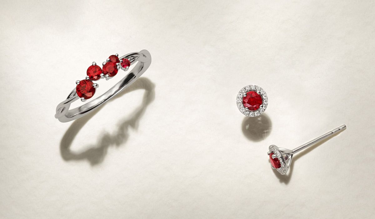 An engraved circle pendant with gemstone charm and an engraved bar necklace