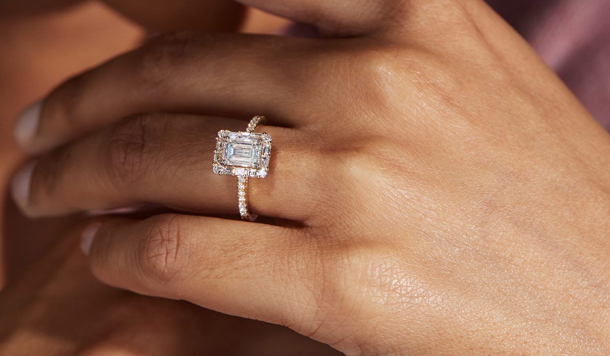 Mobile Image of a woman's hand with an emerald cut diamond engagement ring