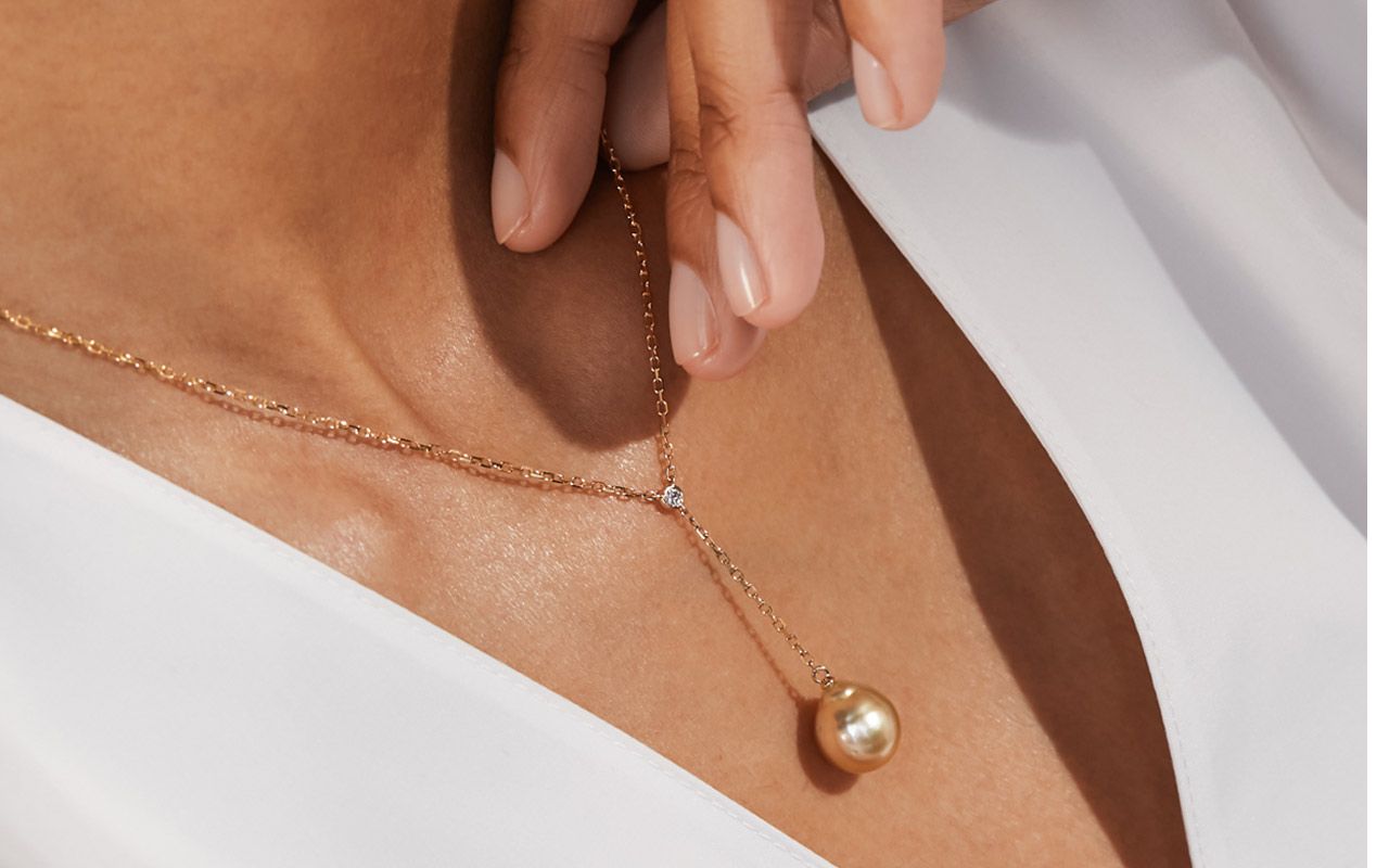 A woman wearing a limited edition pearl pendant necklace