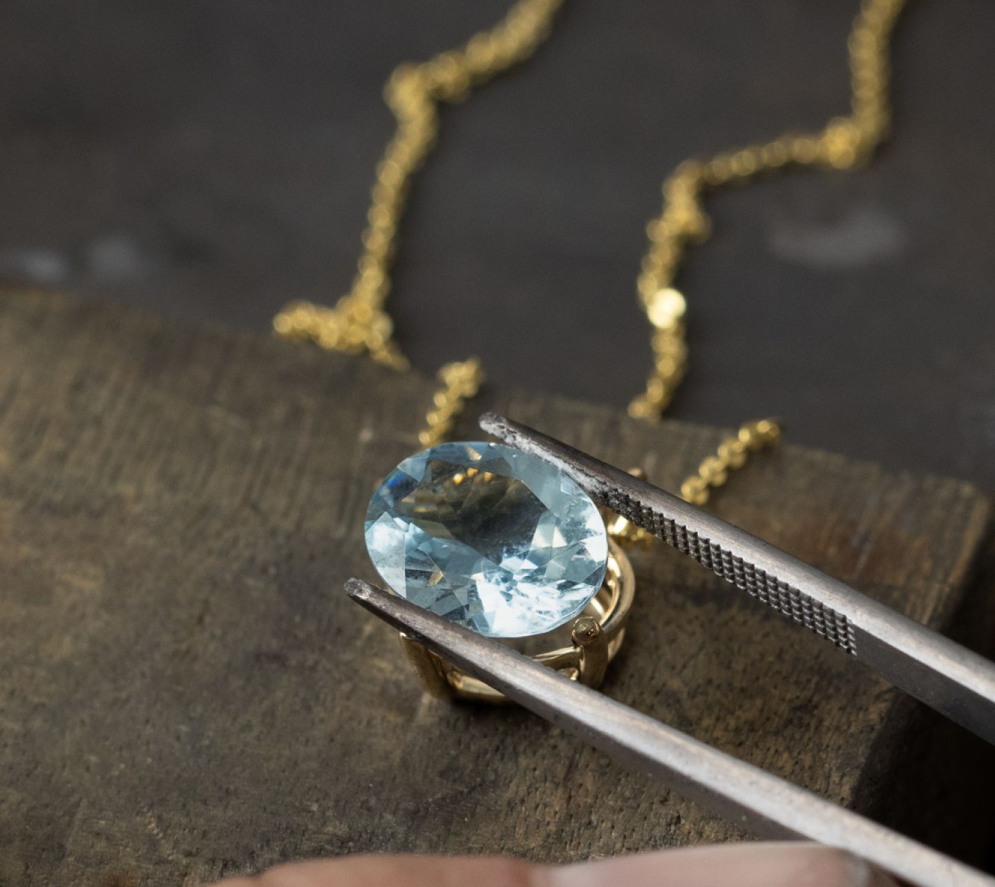A loose gemstone being set into a fashion pendant
