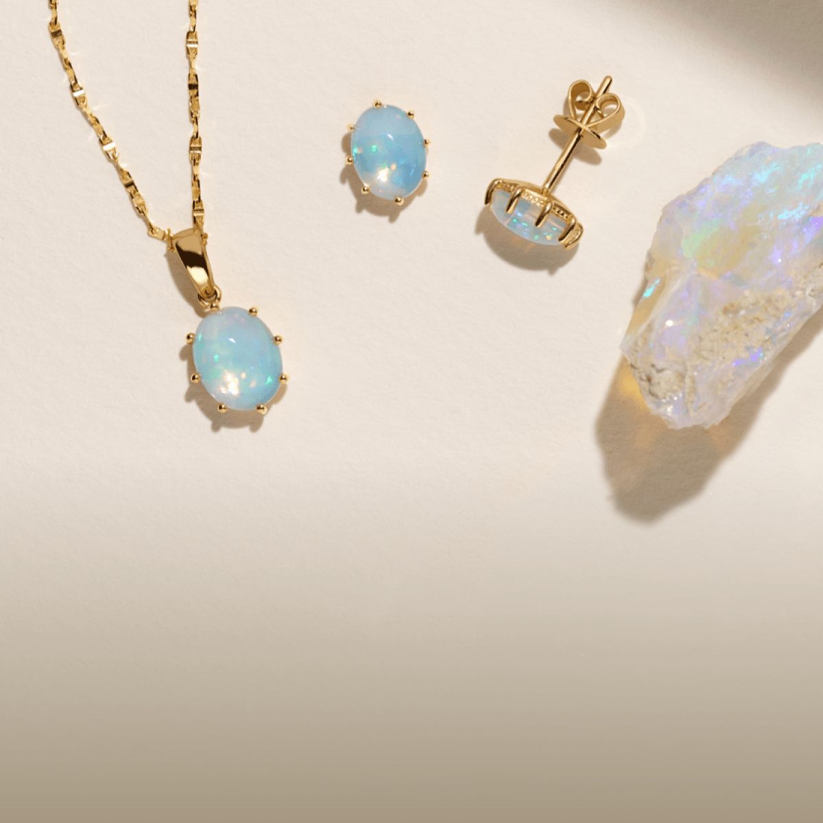 An opal fashion pendant next to a pair of opal stud earrings
