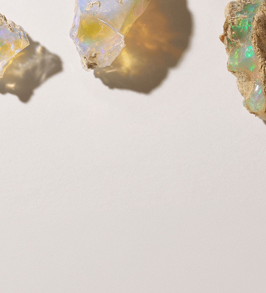 Three uncut opal gemstones on a pale background