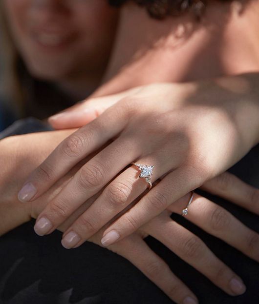 A woman wearing a diamond engagement ring 