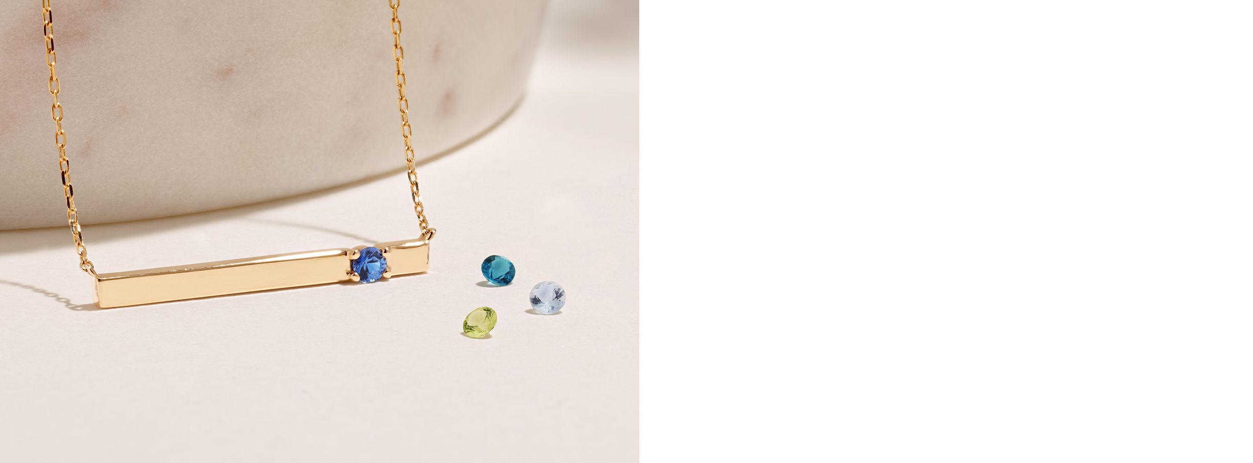 A collection of gemstones with a gold bar necklace