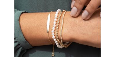 Mobile image of a woman wearing multiple styles of bracelets