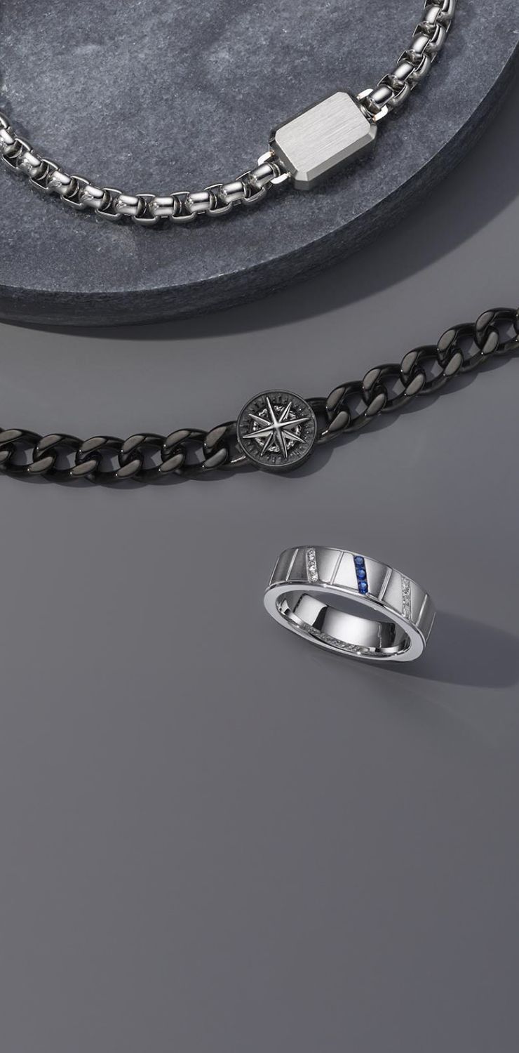 A man wearing a dog tag necklace and a fashion signet ring