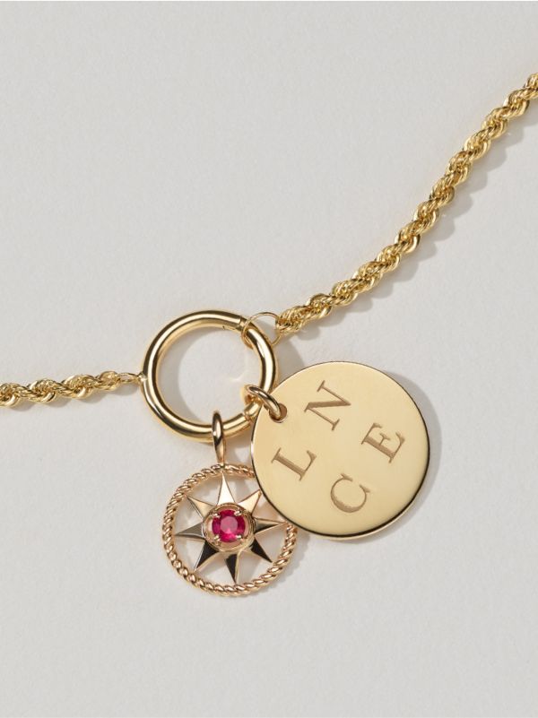 A gemstone charm and an engraved disc charm on a chain